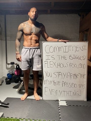 Eddie beside a whiteboard that reads Commitment is the biggest flex