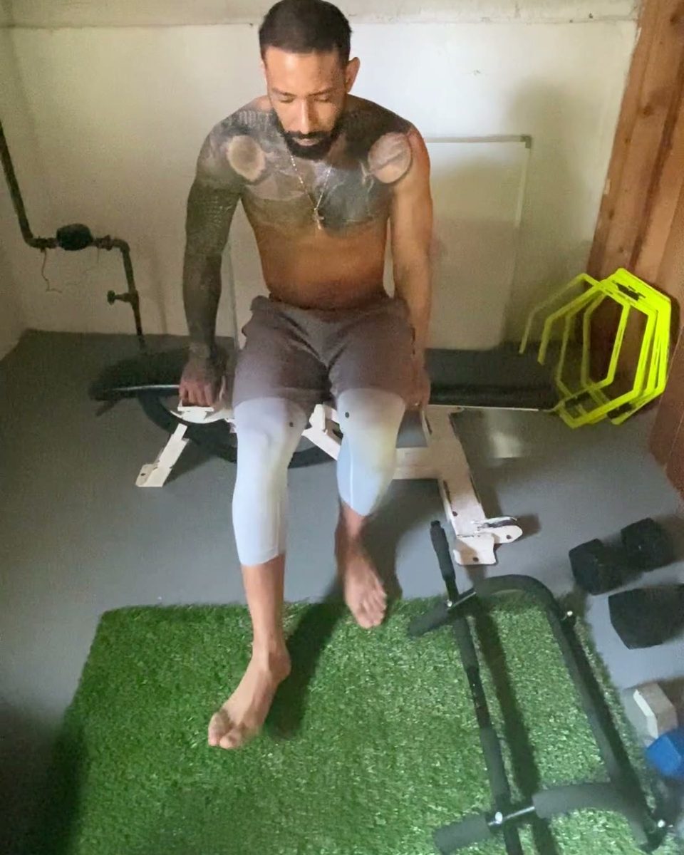 Eddie resting on a bench between sets in his home gym